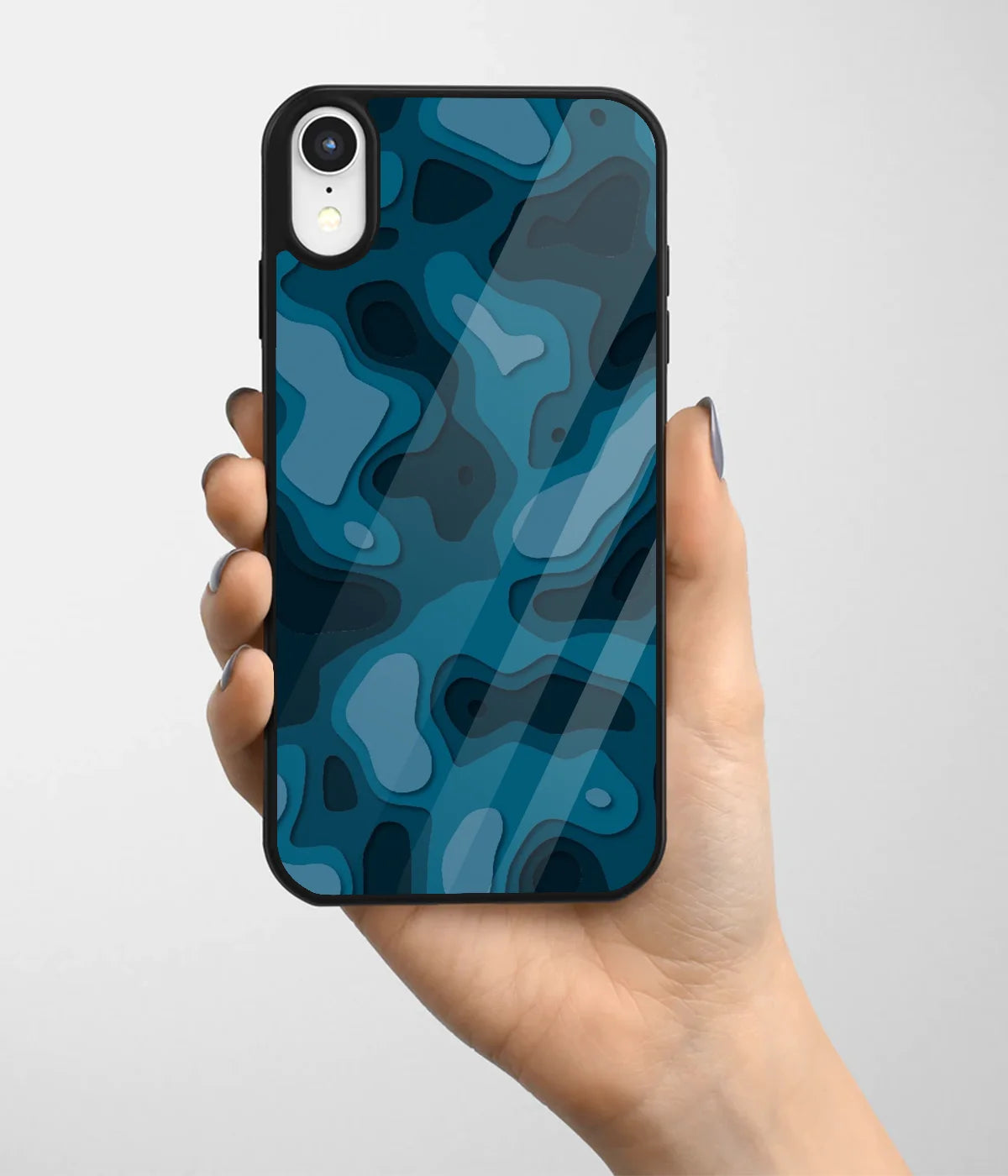 A hand holding a glass phone case with a colorful design.