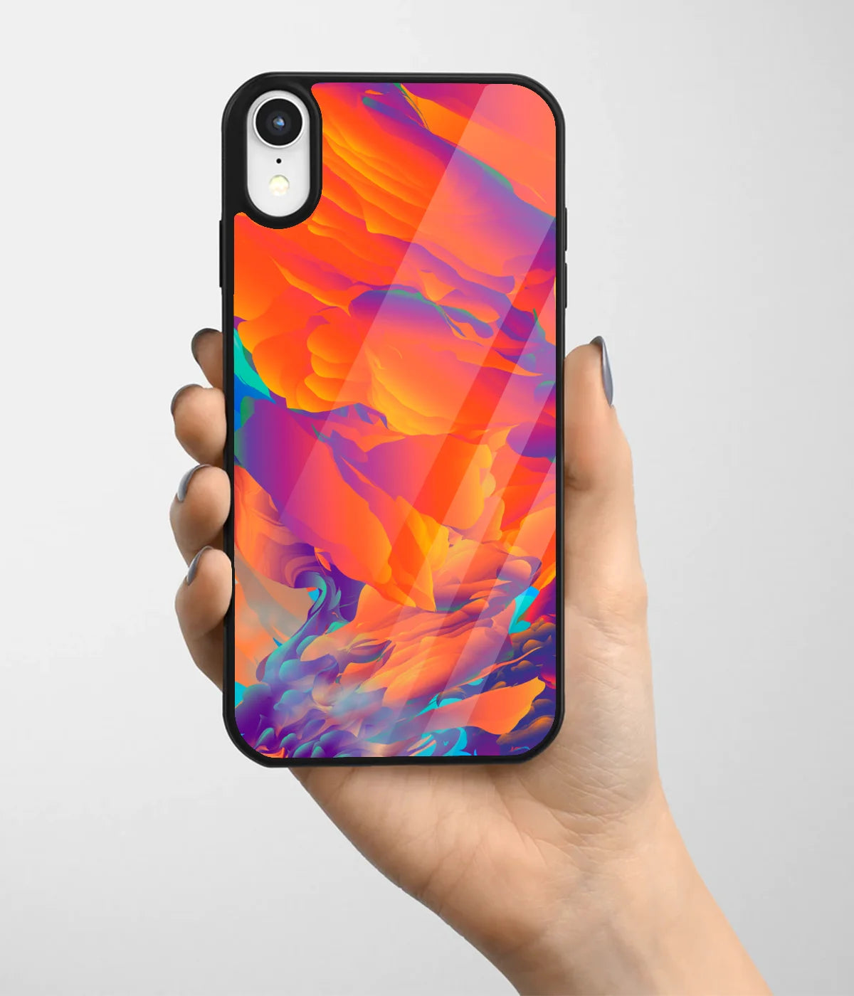 A hand holding a glass phone case with a colorful design.