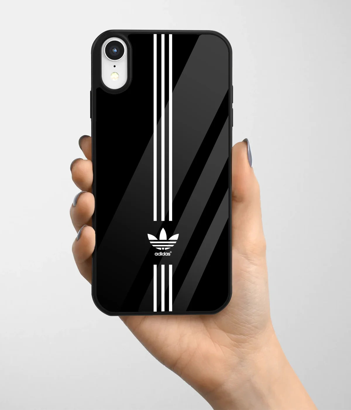 A hand holding a glass phone case with a colorful design.