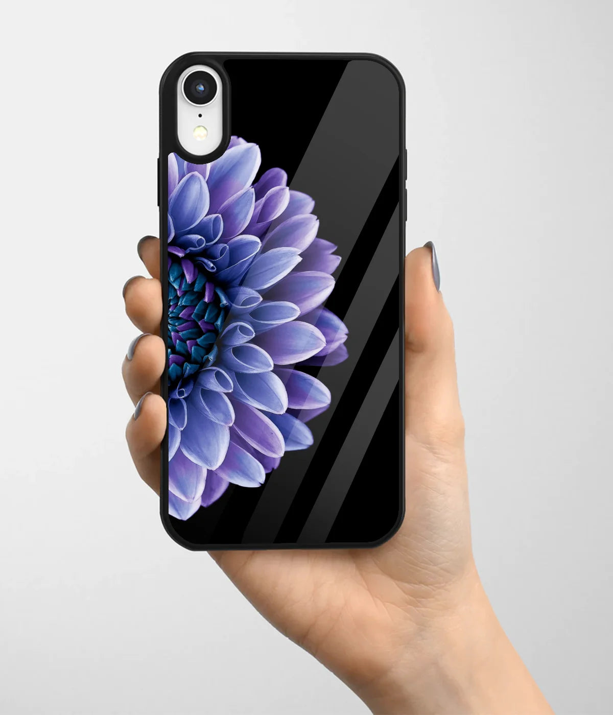 A hand holding a glass phone case with a colorful design.