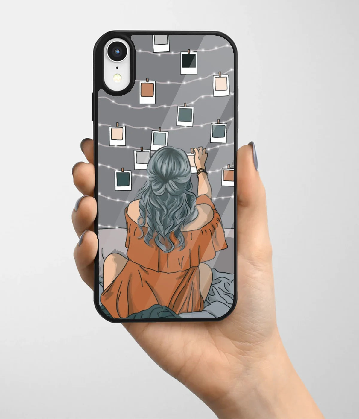 A hand holding a glass phone case with a colorful design.