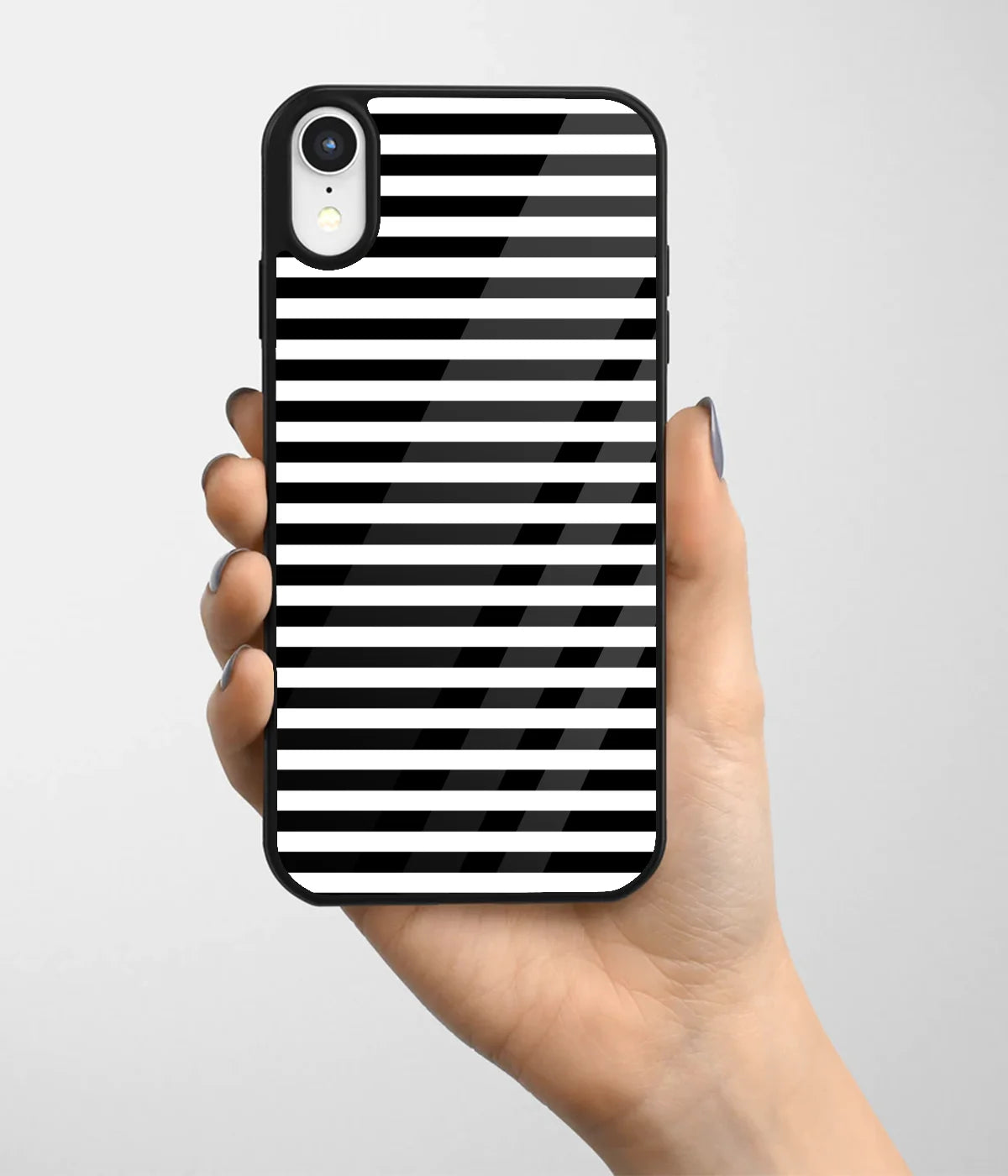 A hand holding a glass phone case with a colorful design.