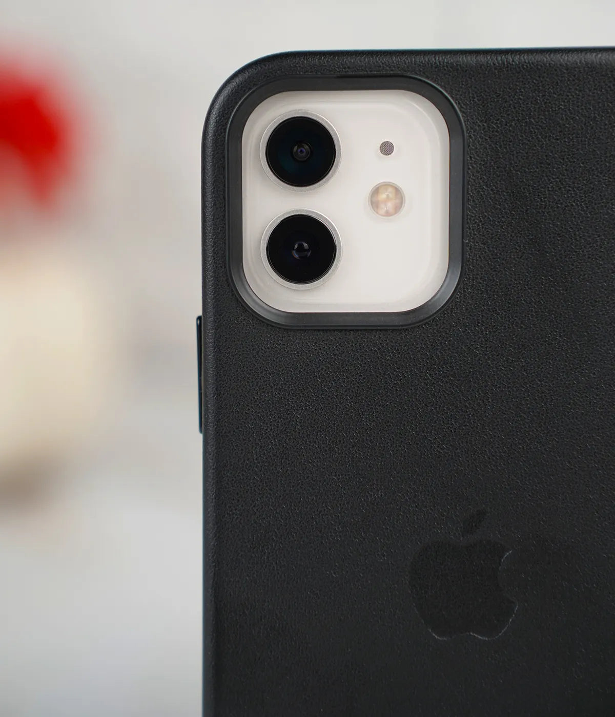 Close-up shot of the premium black leather case for iPhone detailing raised protective lip around the iPhone camera module.