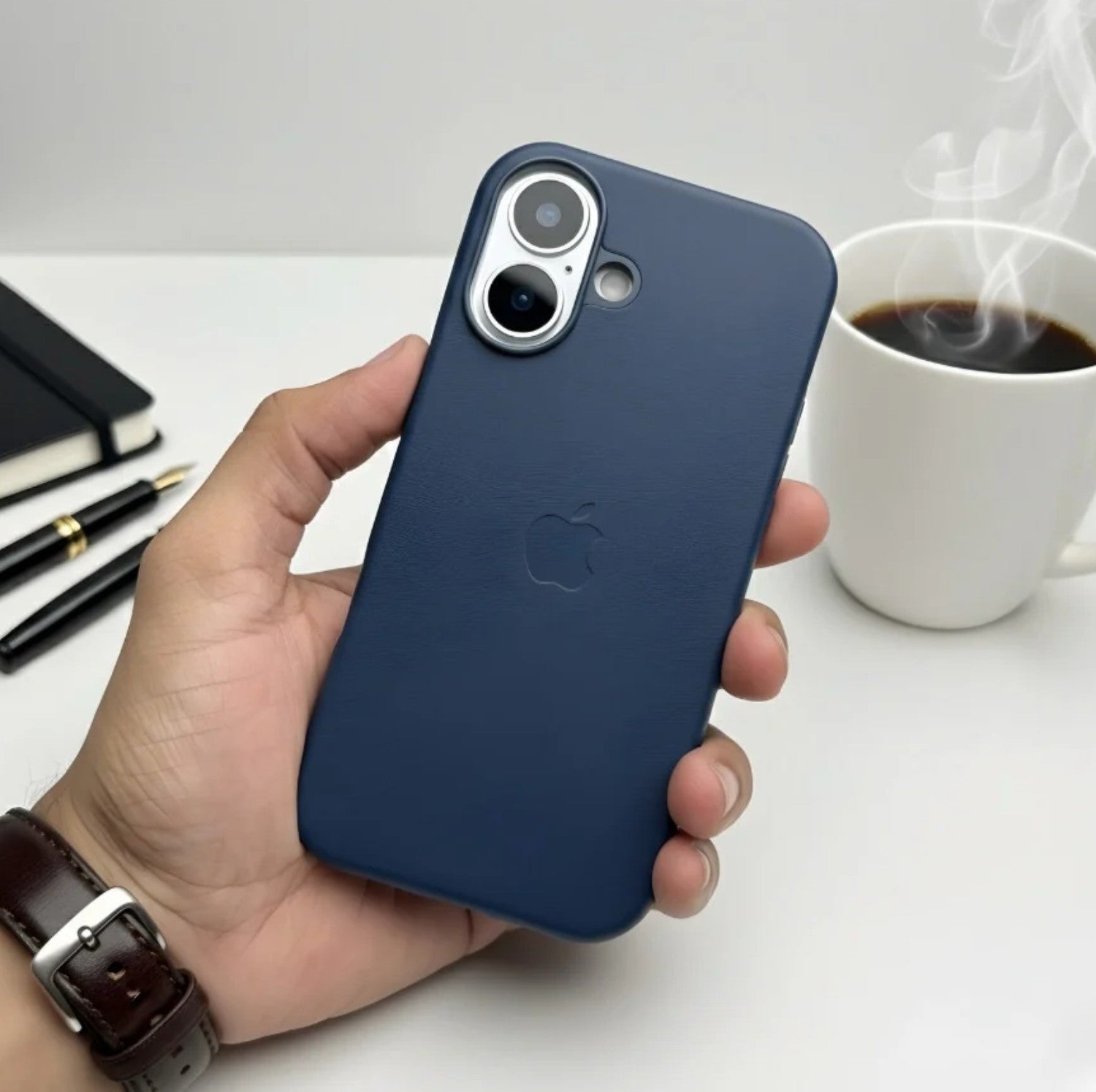 Hand holding a deep navy blue leather MagSafe case for iPhone.