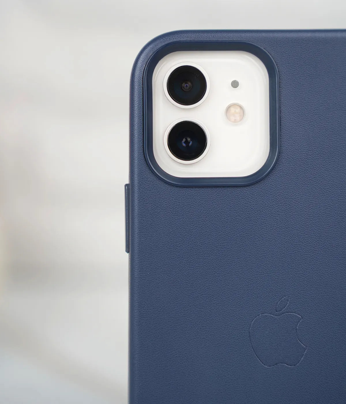 Close-up shot of the premium Deep Navy leather case for iPhone detailing raised protective lip around the iPhone camera module.