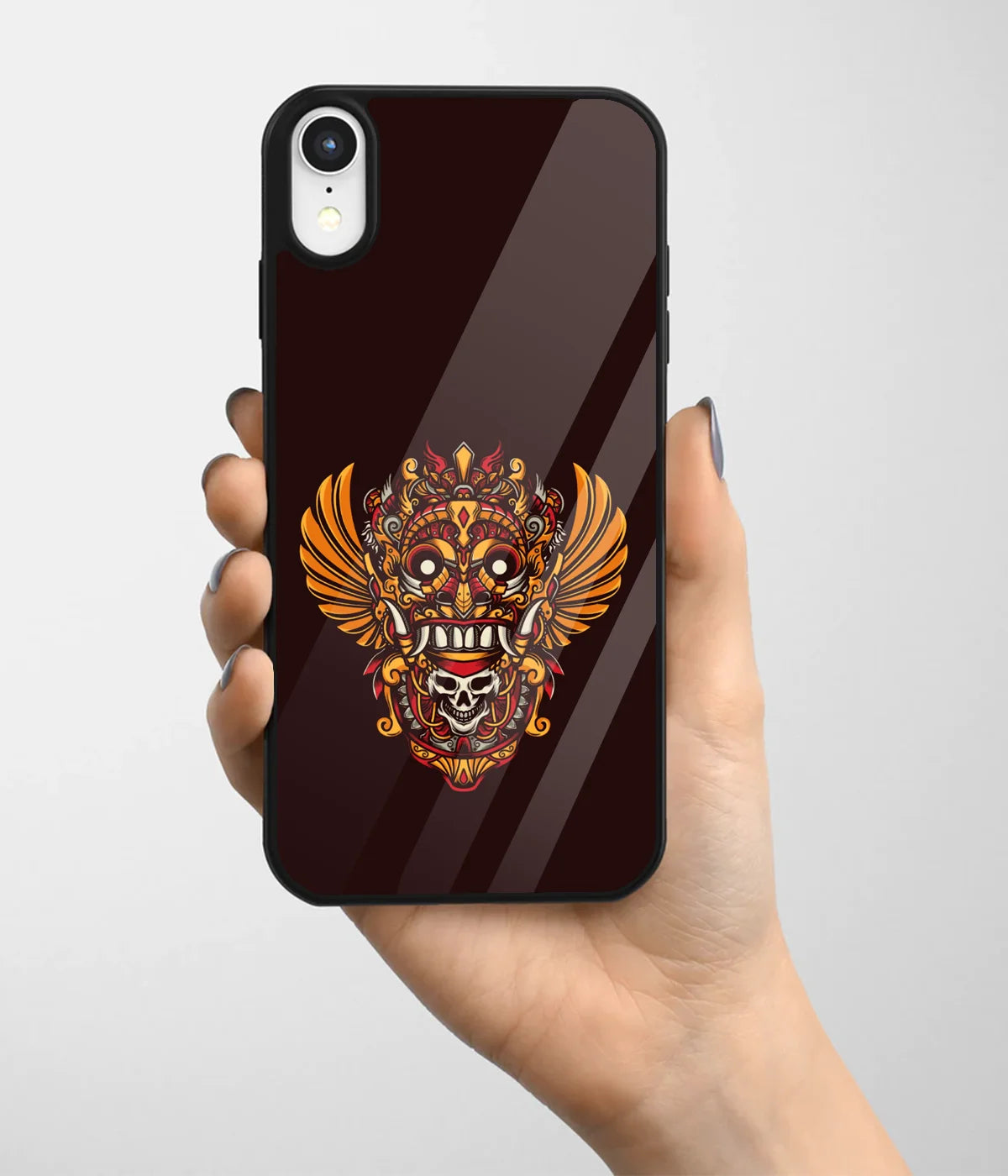 A hand holding a glass phone case with a colorful design.