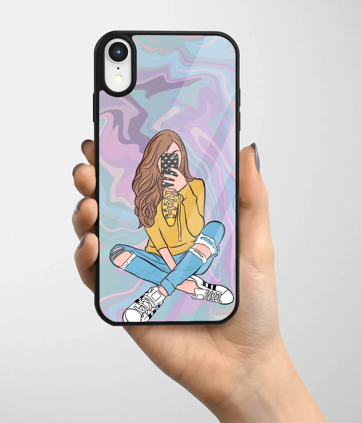 A hand holding a glass phone case with a colorful design.