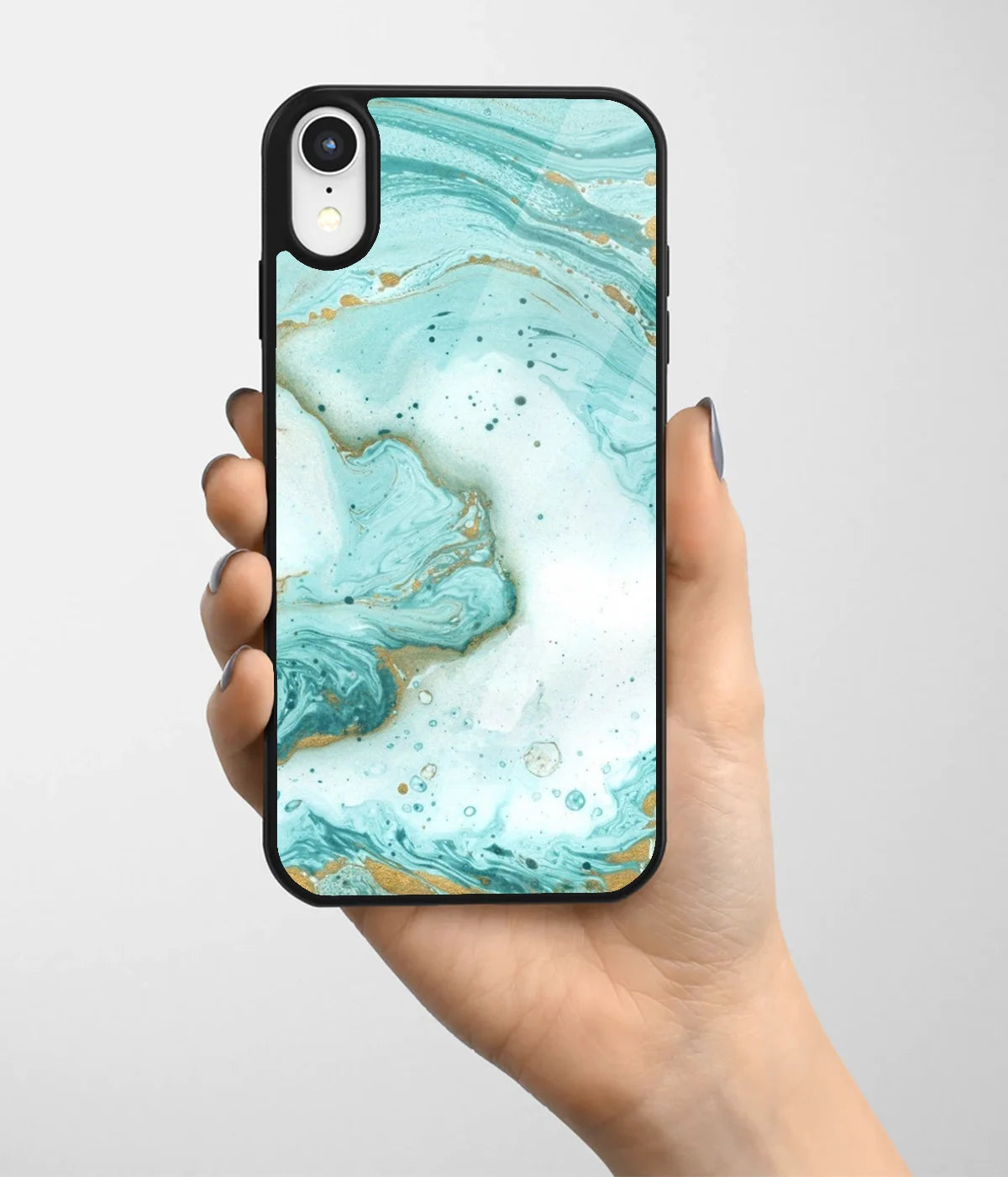 A hand holding a glass phone case with a colorful design.