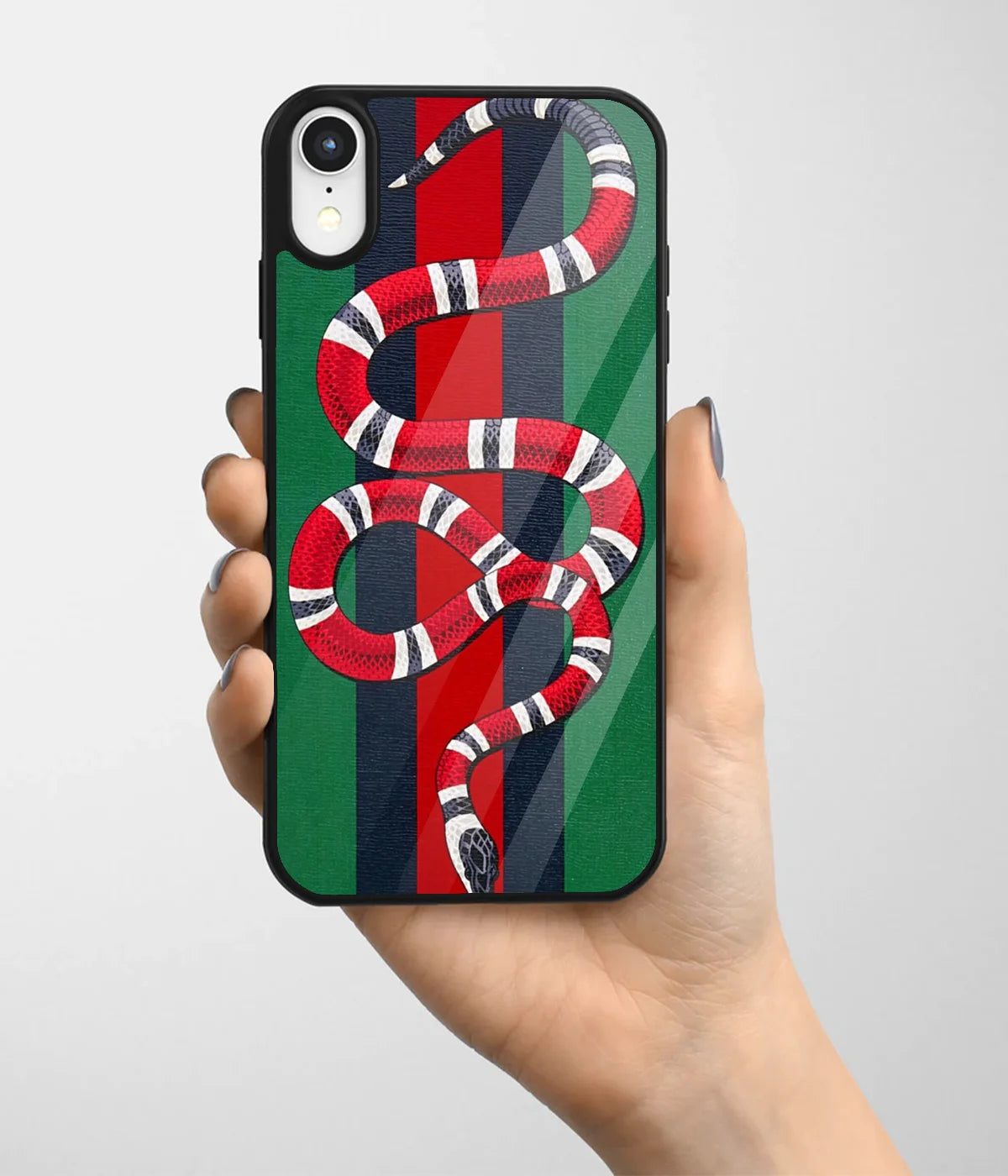 A hand holding a glass phone case with a colorful design.