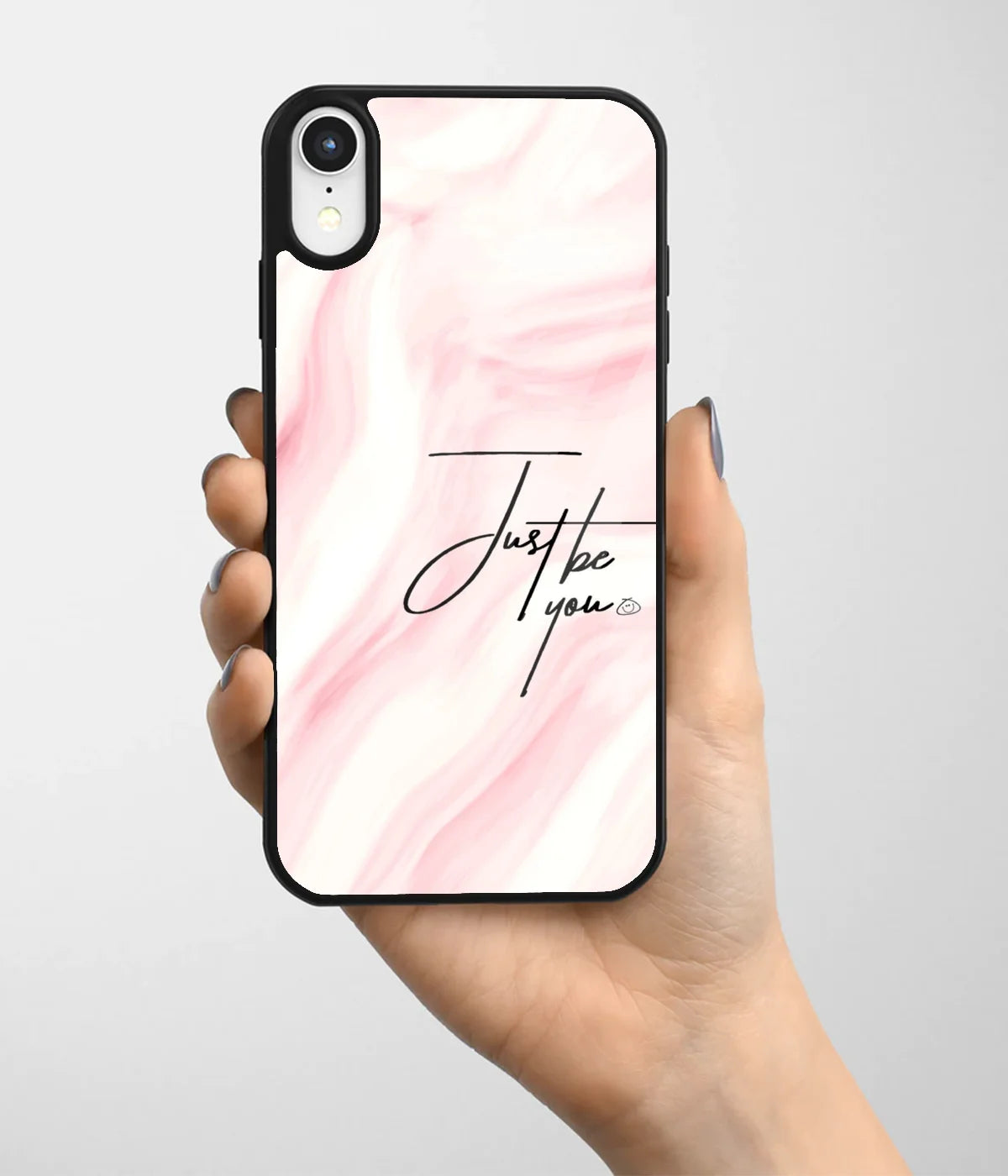 A hand holding a glass phone case with a colorful design.