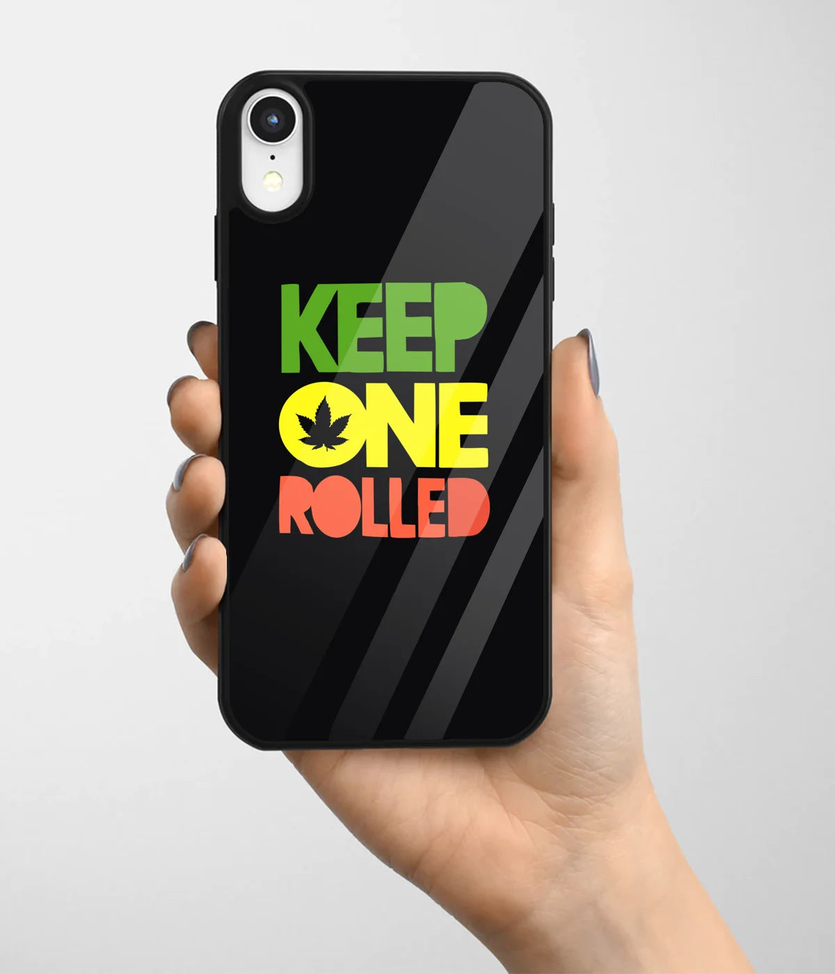 A hand holding a glass phone case with a colorful design.