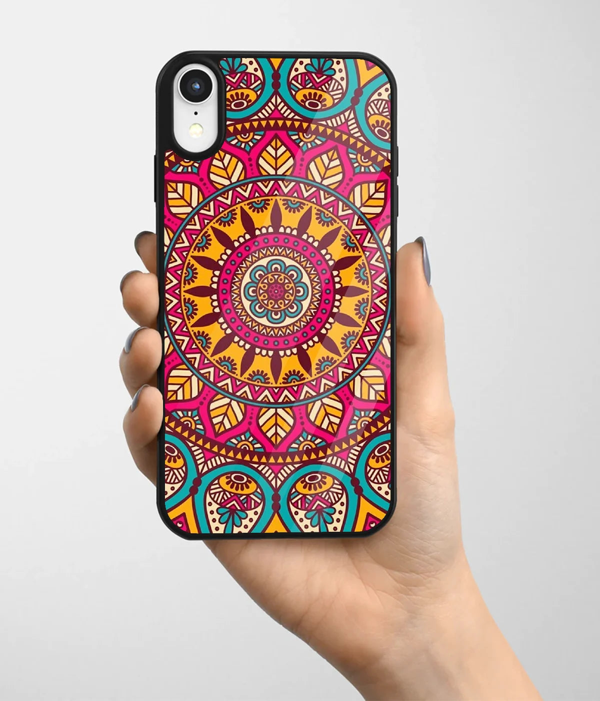 A hand holding a glass phone case with a colorful design.