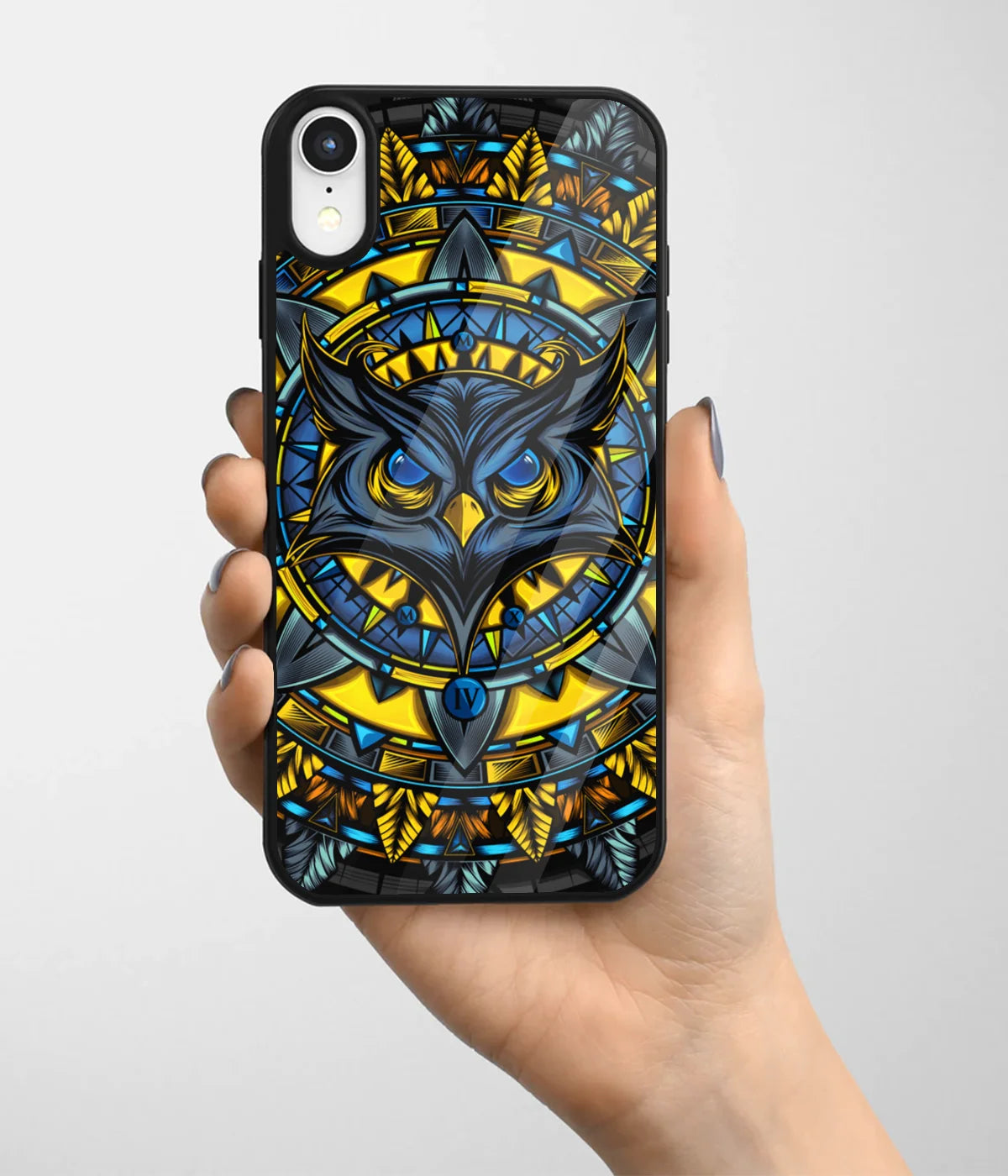 A hand holding a glass phone case with a colorful design.