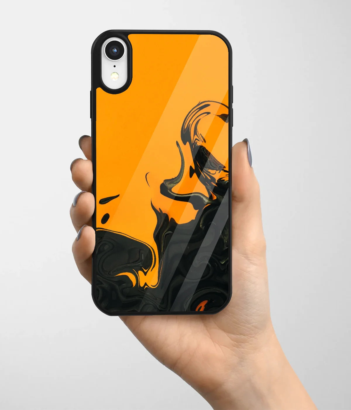 A hand holding a glass phone case with a colorful design.