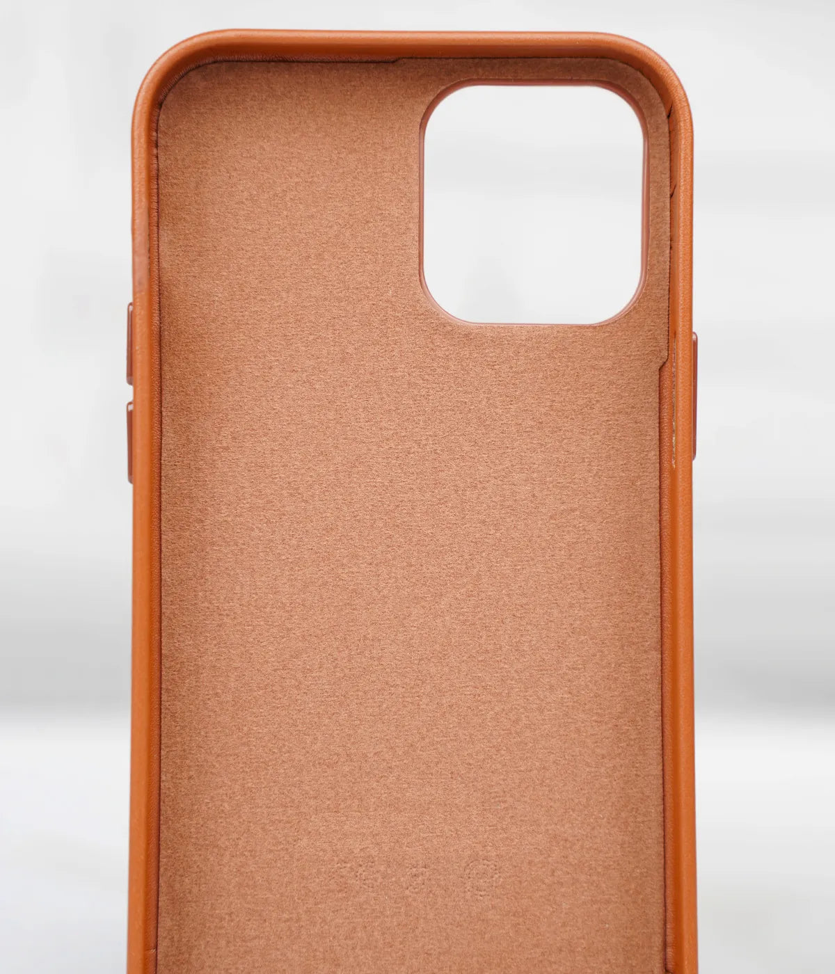 Inside view of the brown premium leather iPhone case showing the soft interior lining designed to protect the back of the phone from scratches.