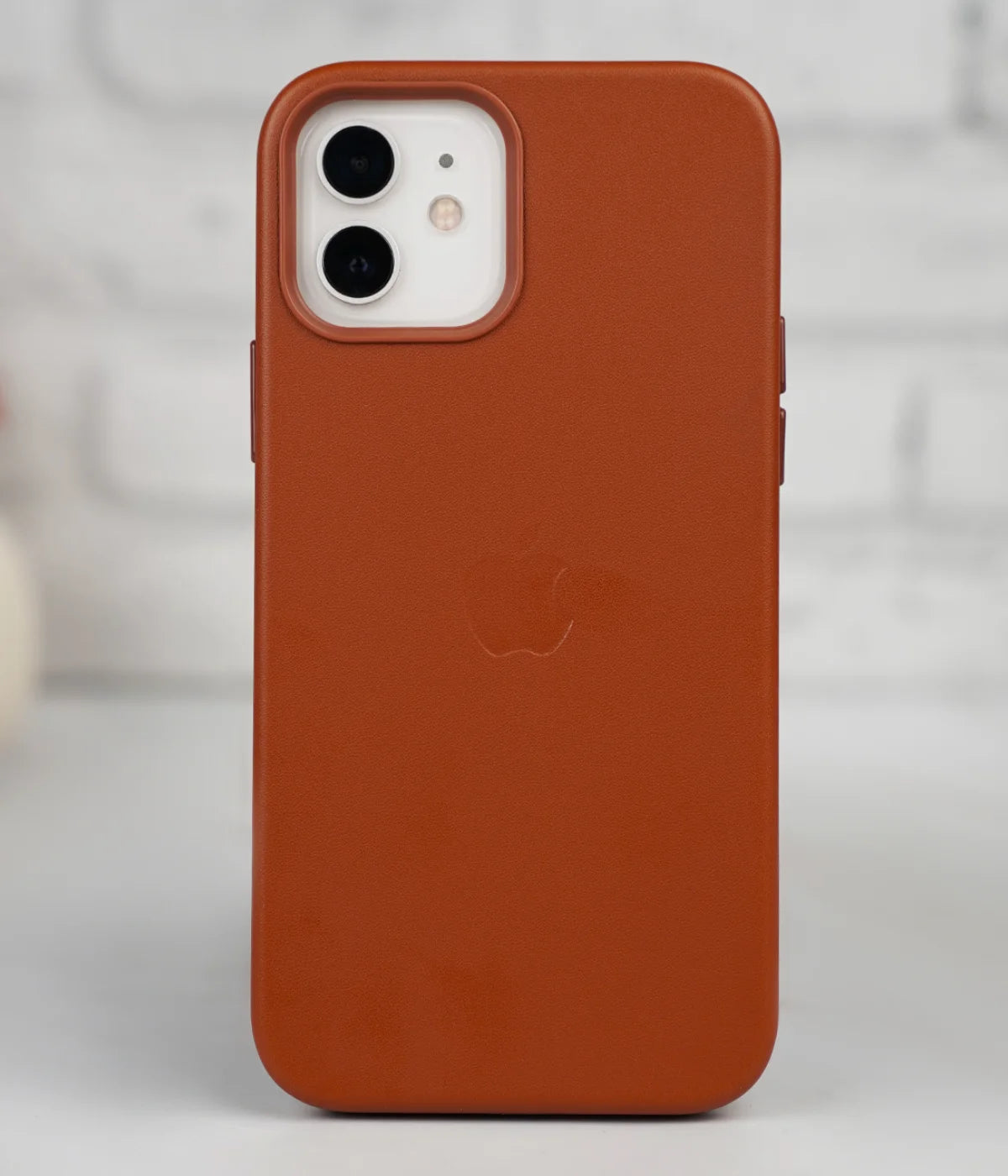 Full back view of an iPhone protected by the premium brown leather case, featuring a sleek design and an embossed Apple logo.