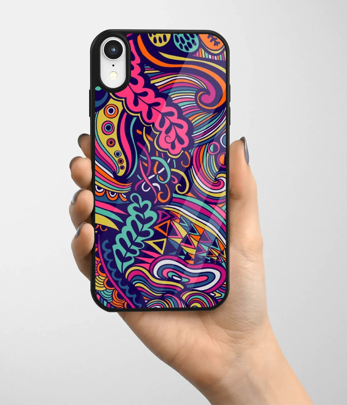 A hand holding a glass phone case with a colorful design.