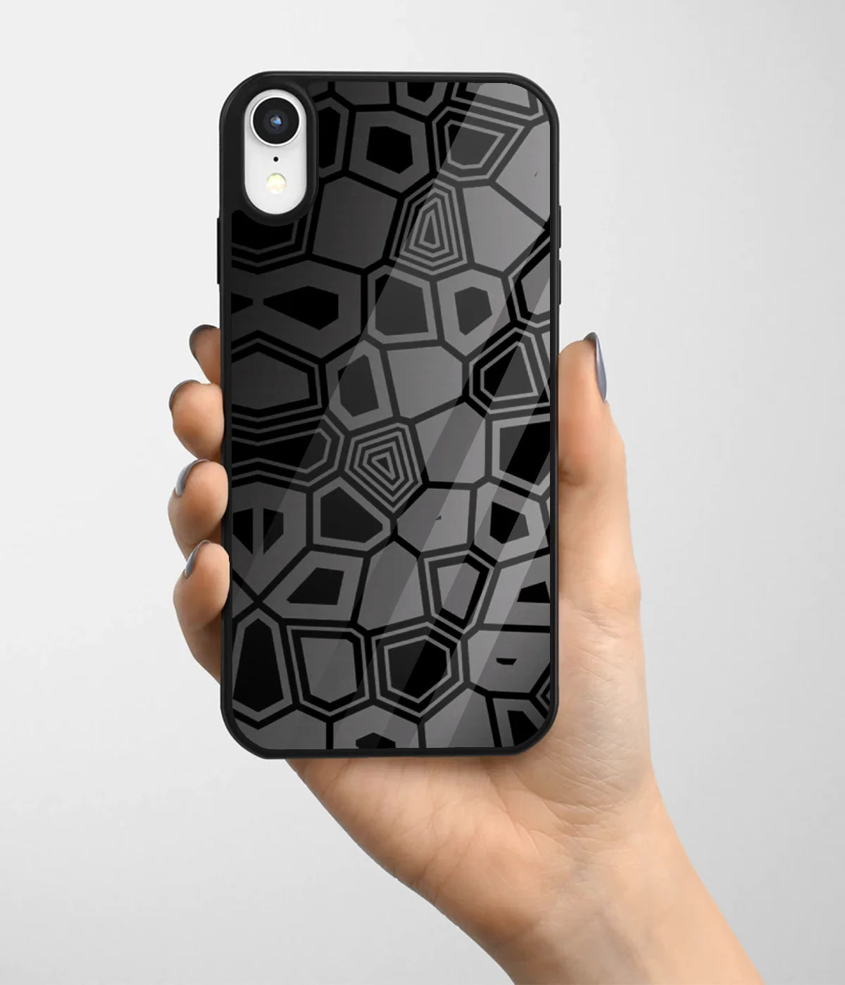 A hand holding a glass phone case with a colorful design.