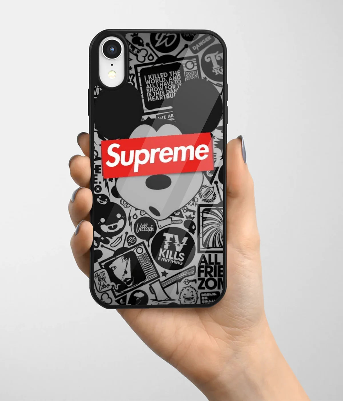A hand holding a glass phone case with a colorful design.