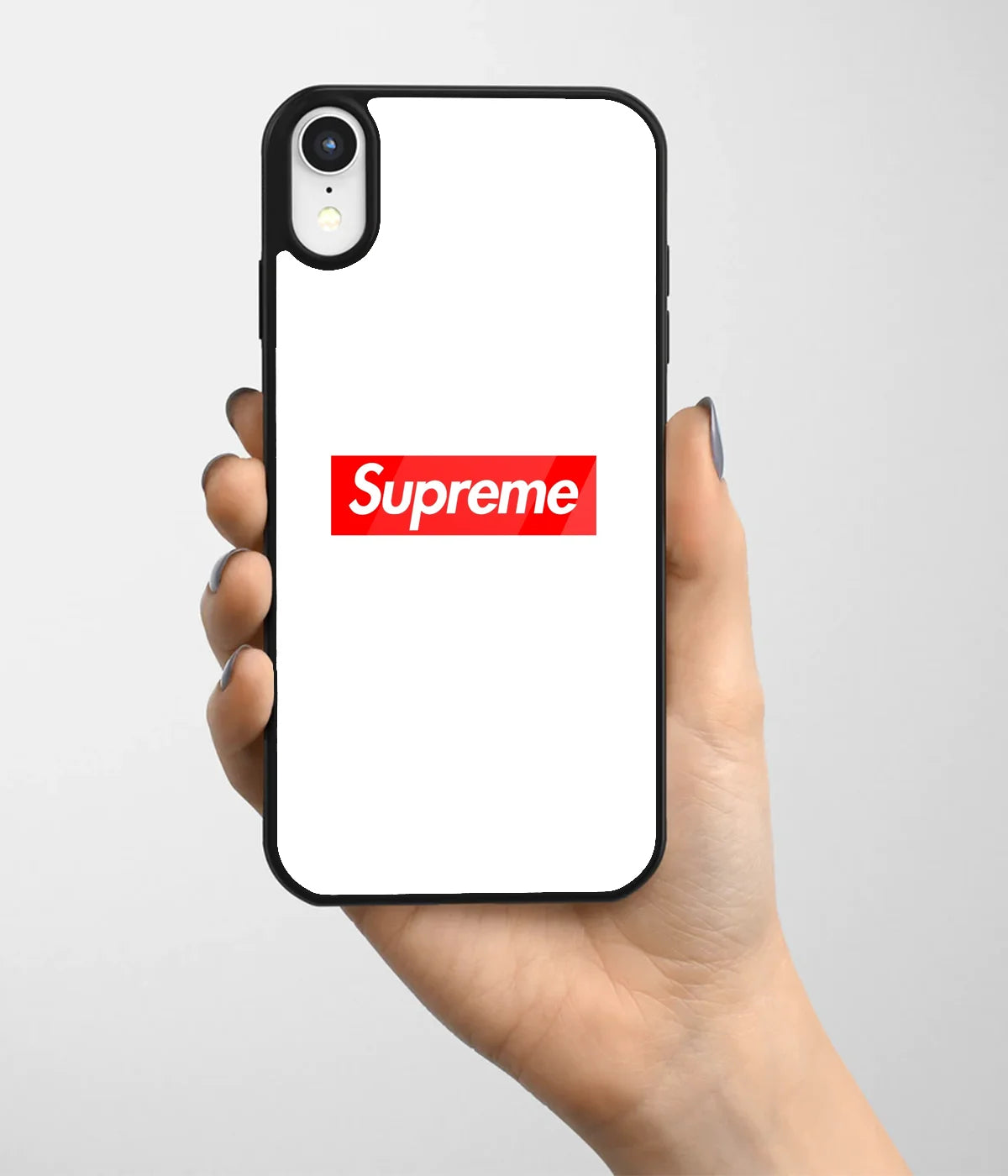 A hand holding a glass phone case with a colorful design.