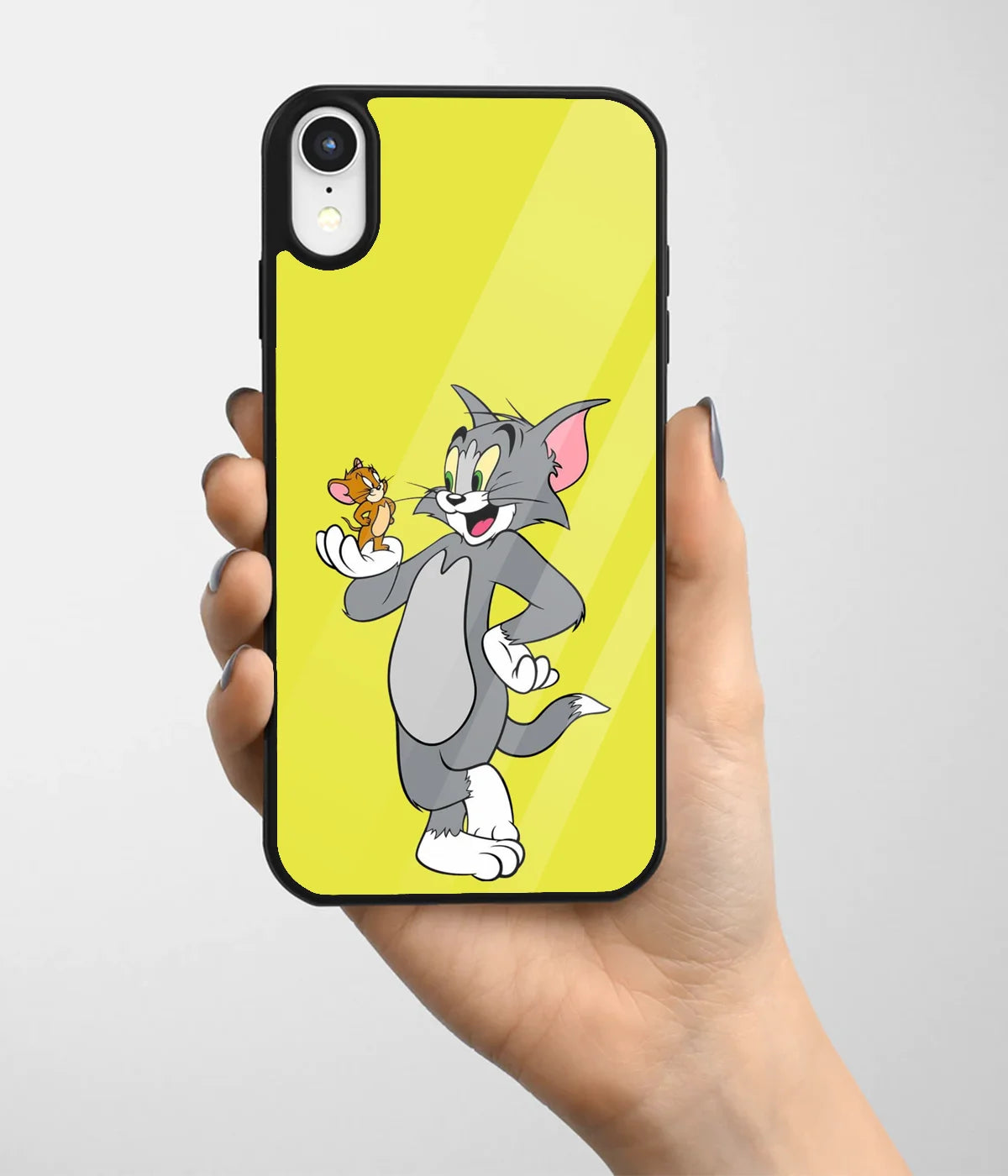 A hand holding a glass phone case with a colorful design.