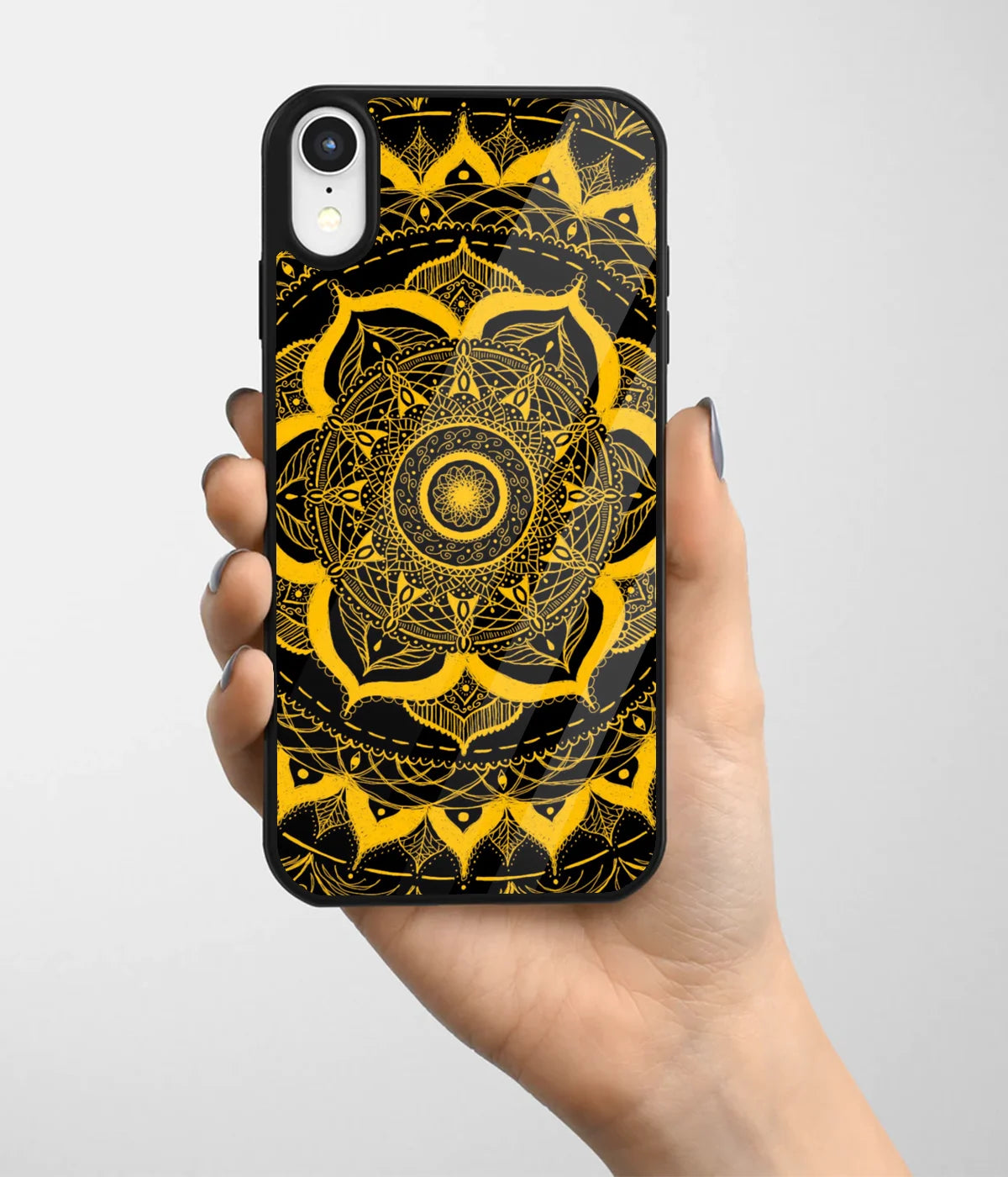 A hand holding a glass phone case with a colorful design.