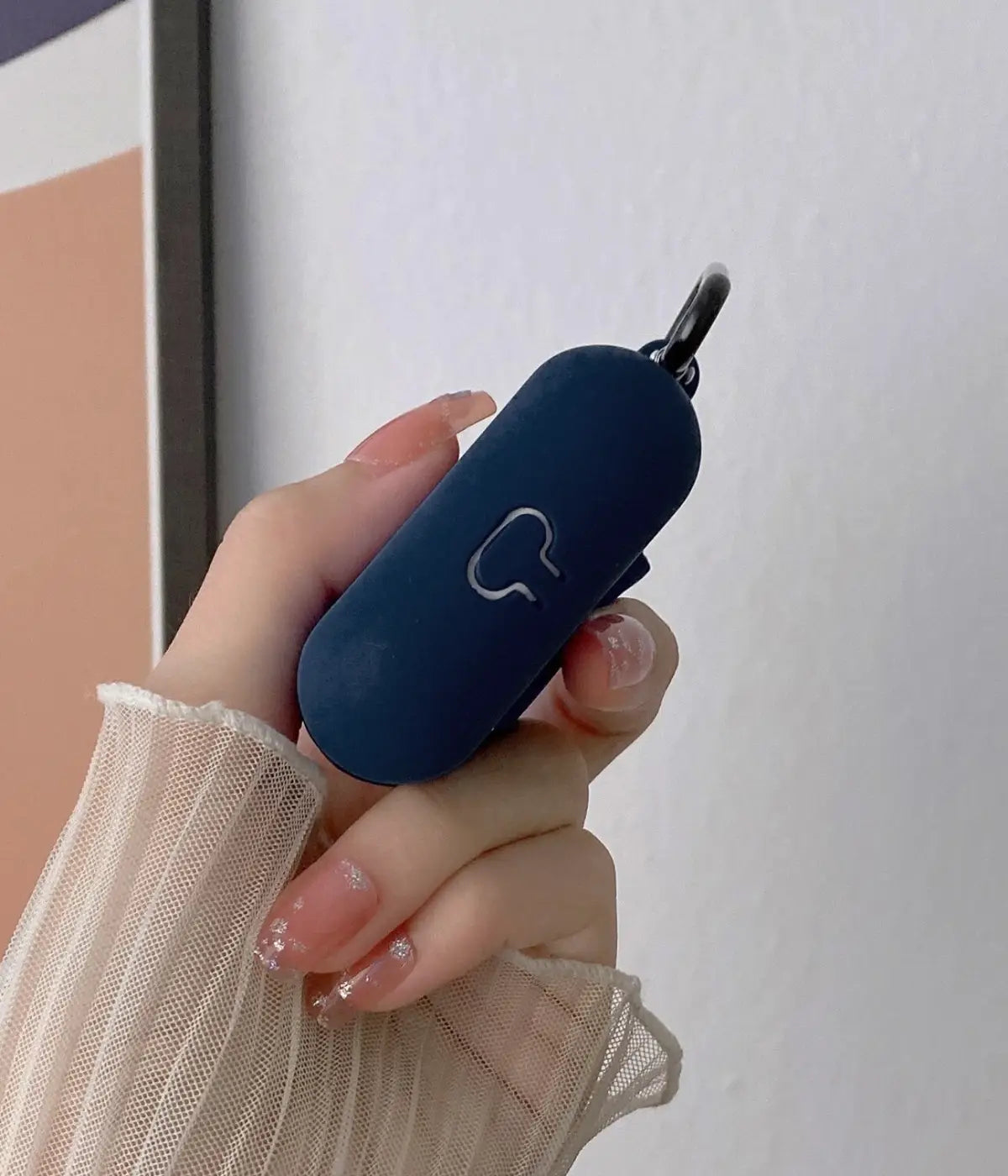 Close-up of a Deep Navy liquid silicone protective case for Apple AirPods held in a hand
