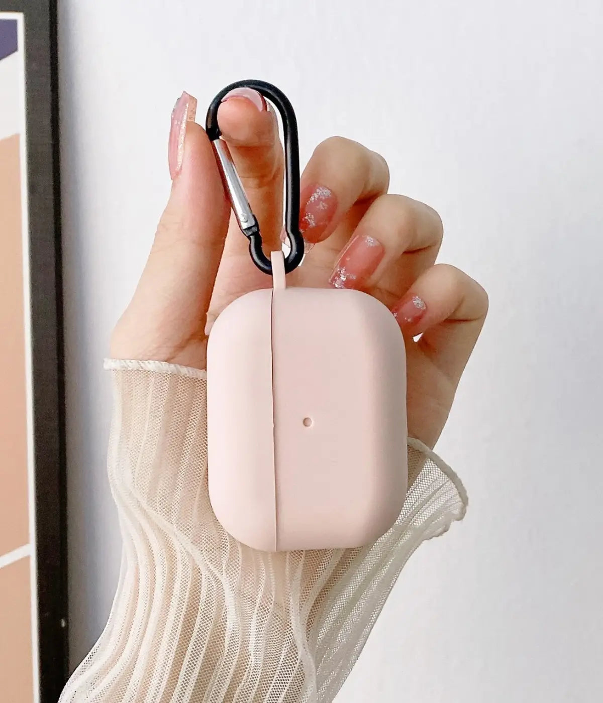 Sand Pink airpods case with carabiner held by a hand.