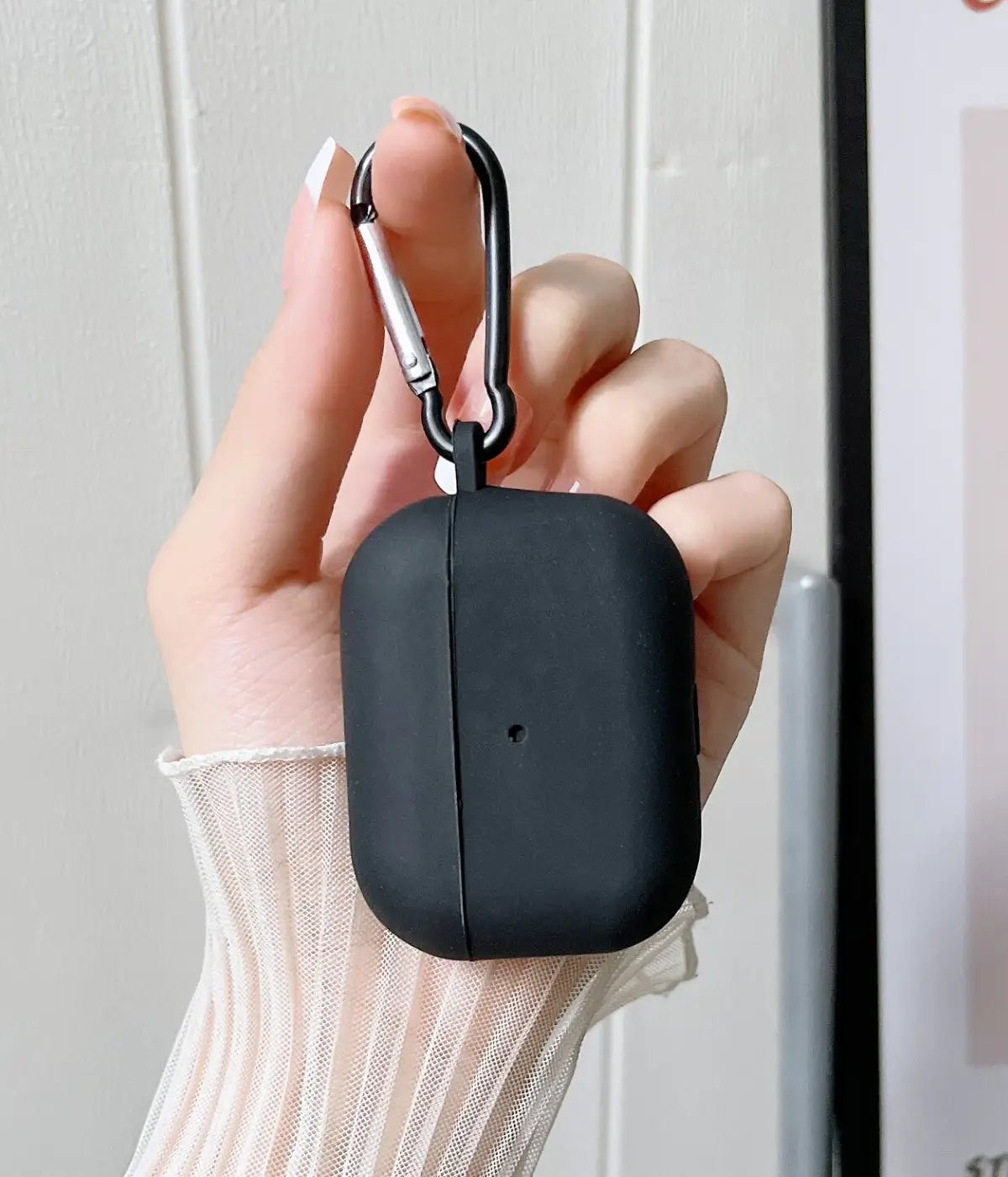 Black airpods case with carabiner held by a hand.