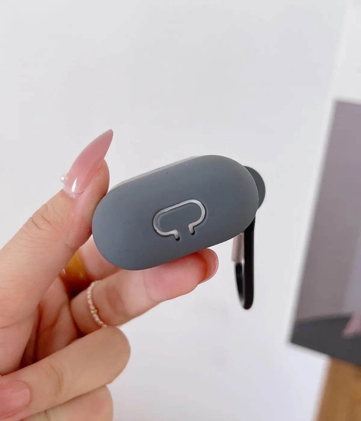 Close-up of a Dark Grey liquid silicone protective case for Apple AirPods held in a hand