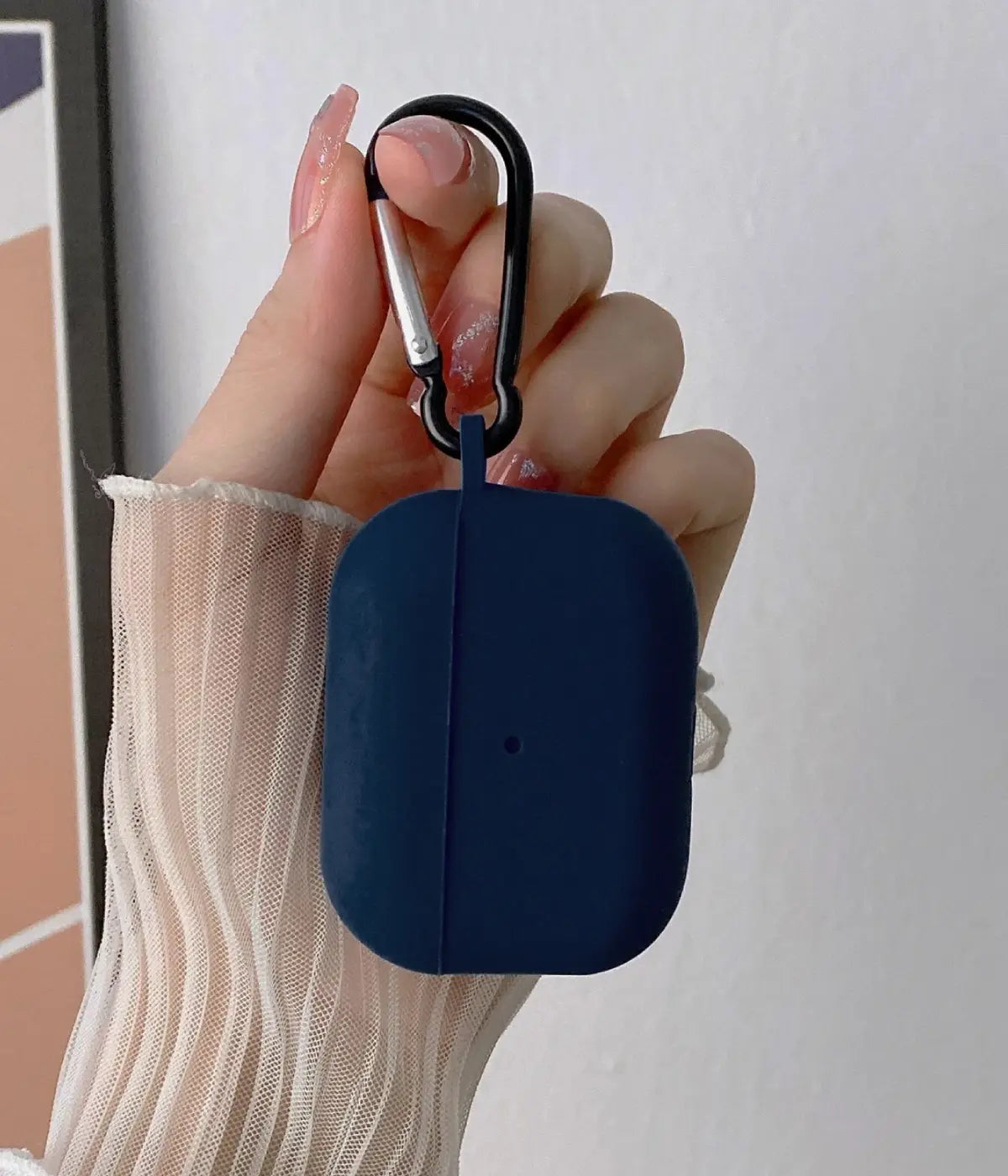 Deep Navy airpods case with carabiner held by a hand.