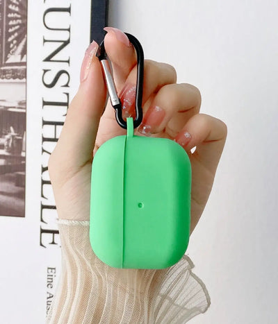 Mint green airpods case with carabiner held by a hand.