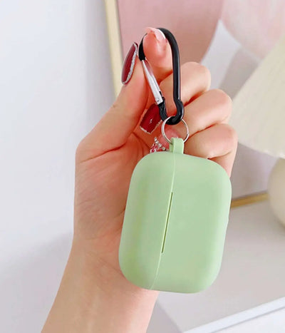 Pistachio Green airpods case with carabiner held by a hand.