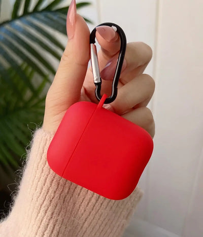 Red airpods case with carabiner held by a hand.