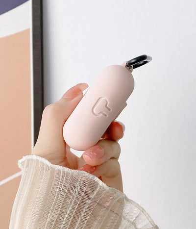 Close-up of a Sand Pink liquid silicone protective case for Apple AirPods held in a hand