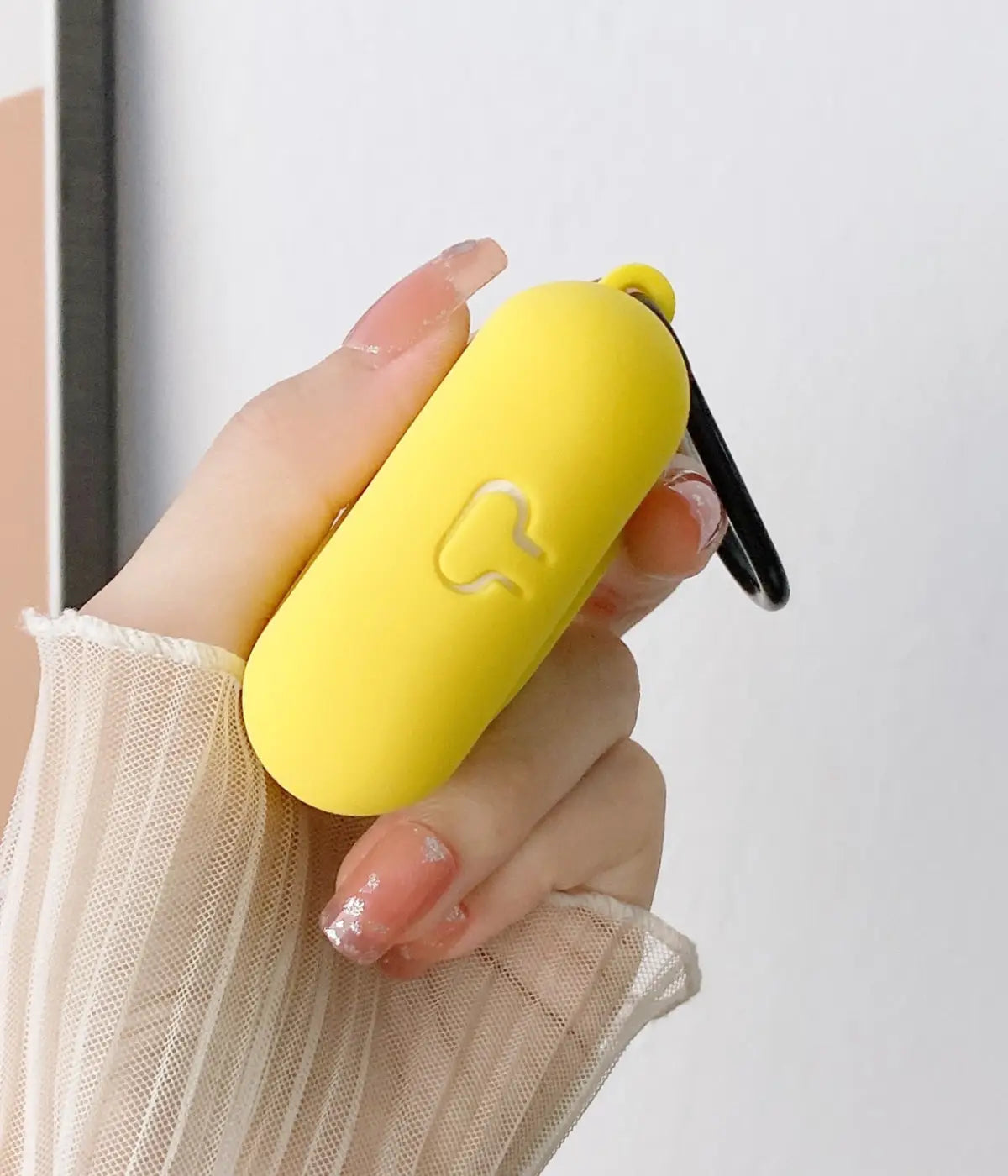 Close-up of a Yellow liquid silicone protective case for Apple AirPods held in a hand