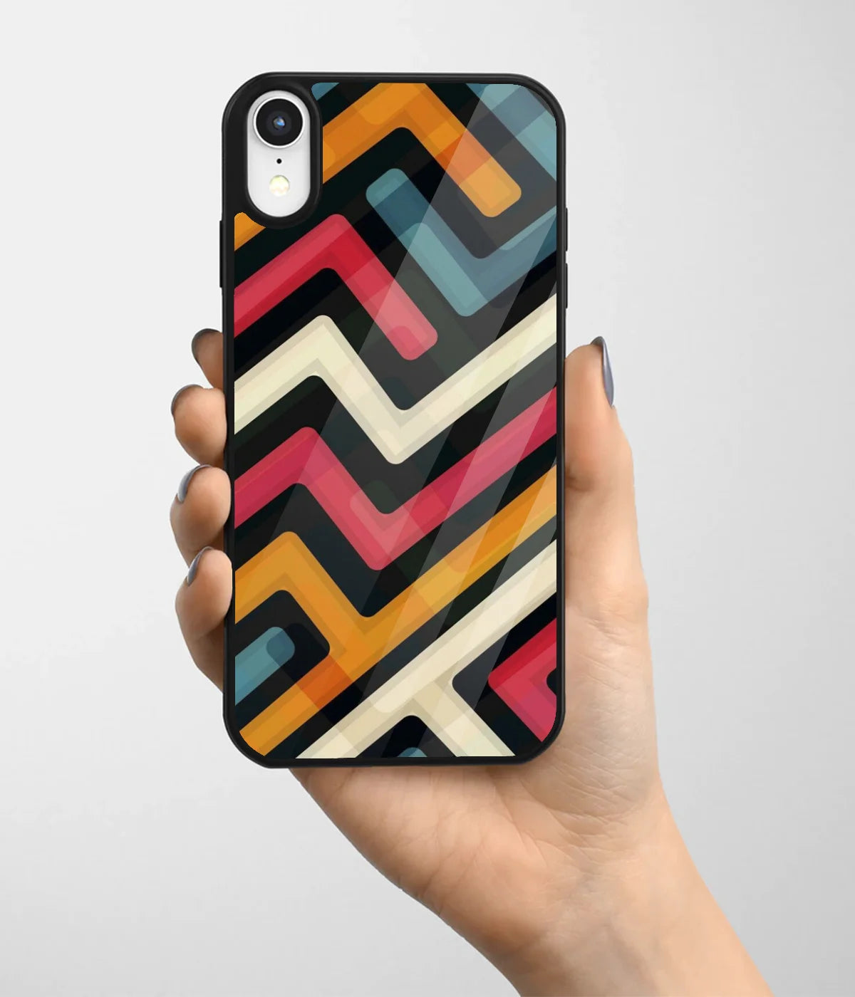 A hand holding a glass phone case with a colorful design.