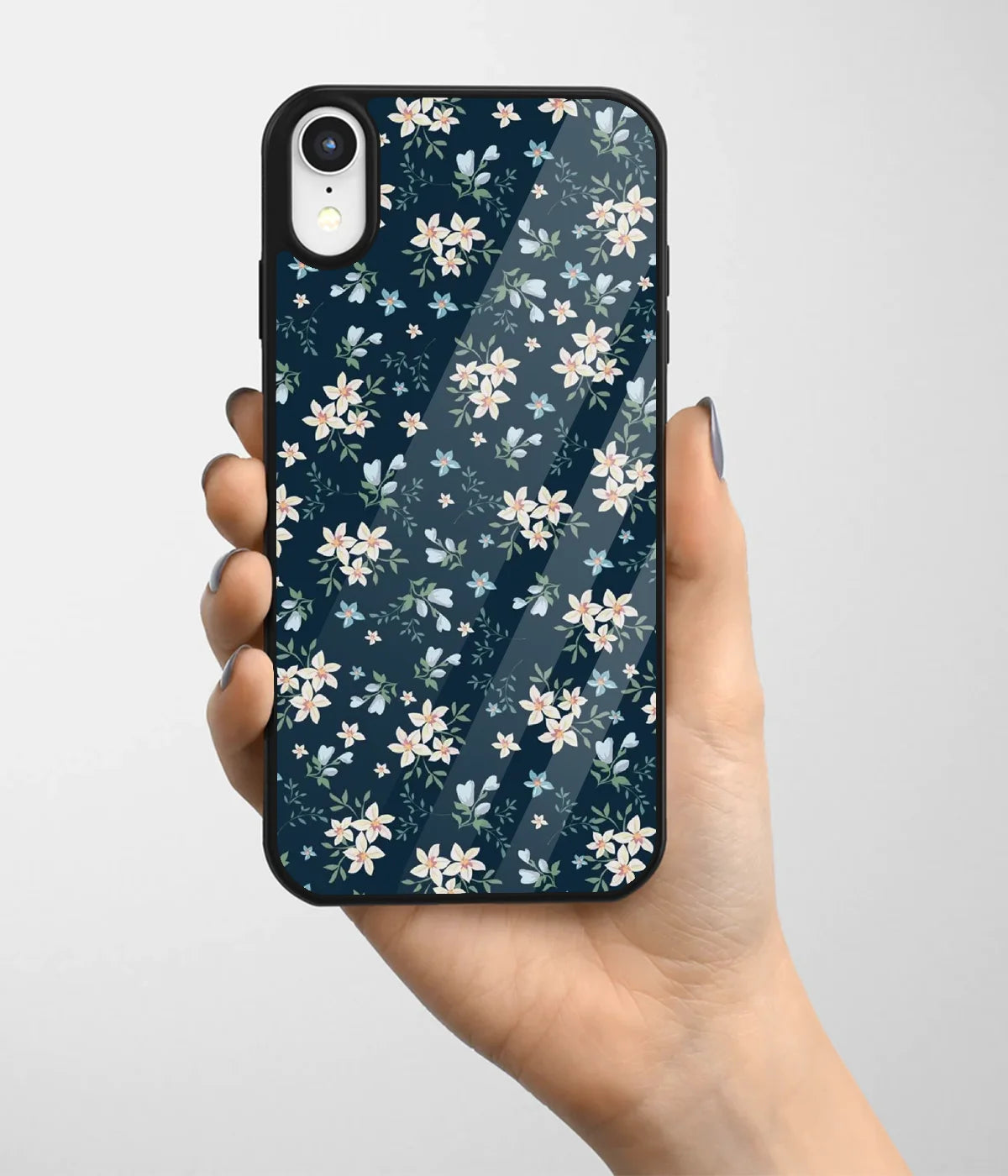 A hand holding a glass phone case with a colorful design.