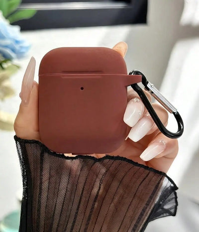 Brown airpods case with carabiner held by a hand.