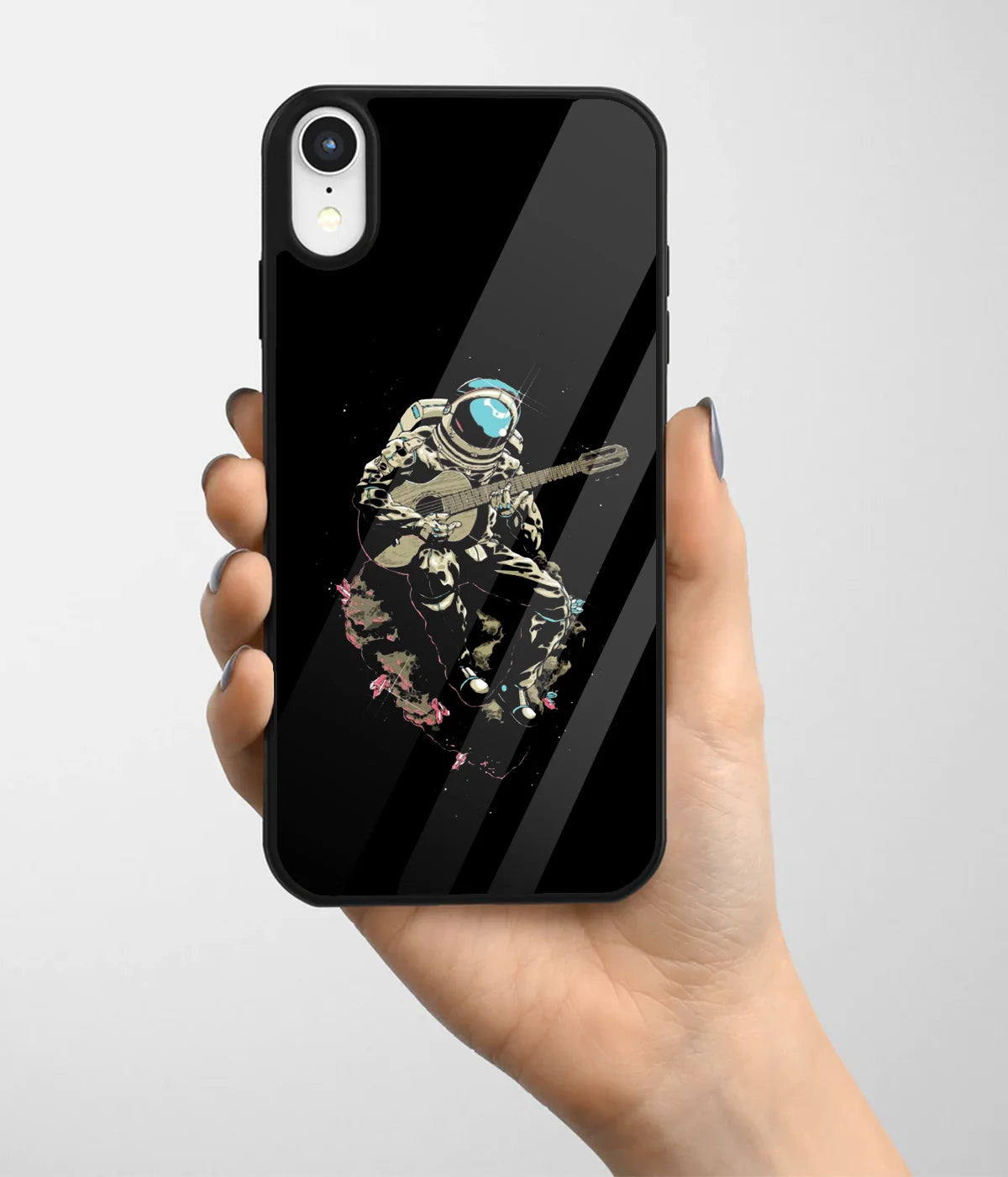 A hand holding a glass phone case with a colorful design.