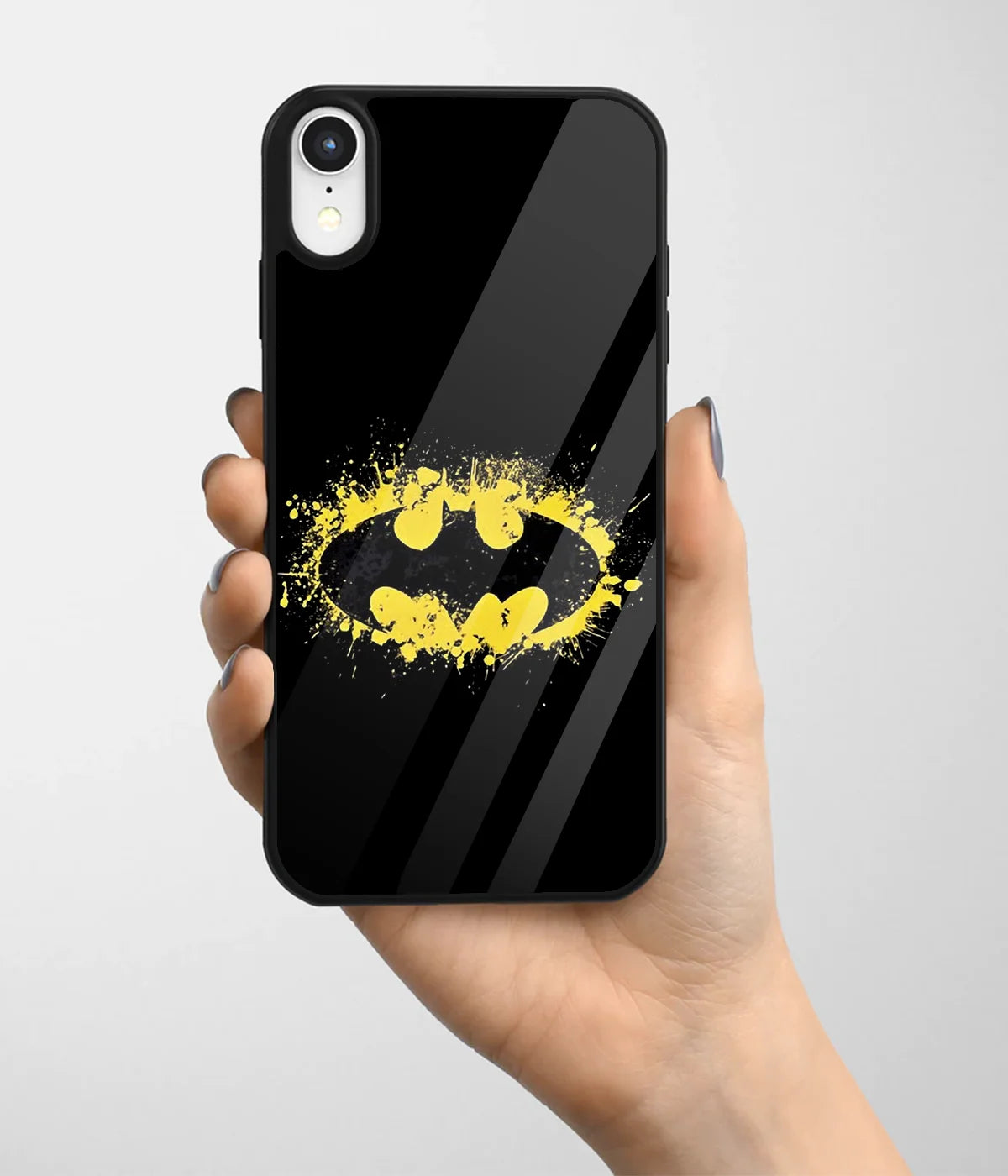 A hand holding a glass phone case with a colorful design.