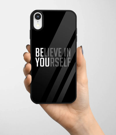 A hand holding a glass phone case with a colorful design.