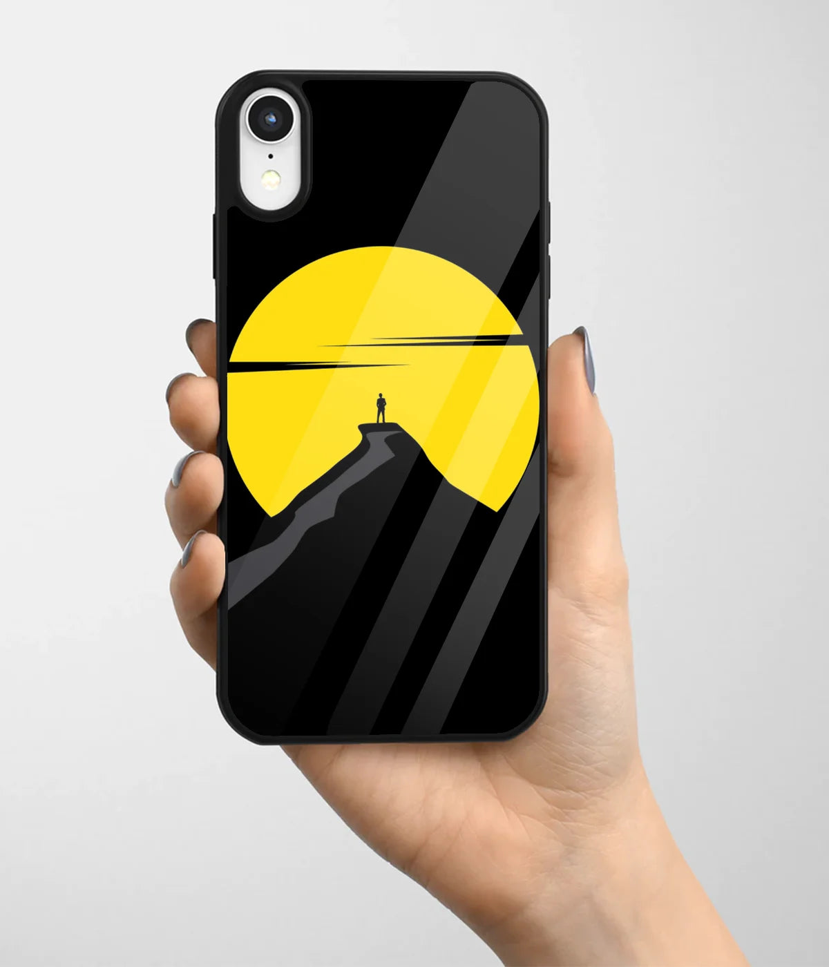 A hand holding a glass phone case with a colorful design.