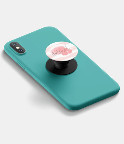 A top-down view of a phone grip holder attached to a mobile phone case on a white background