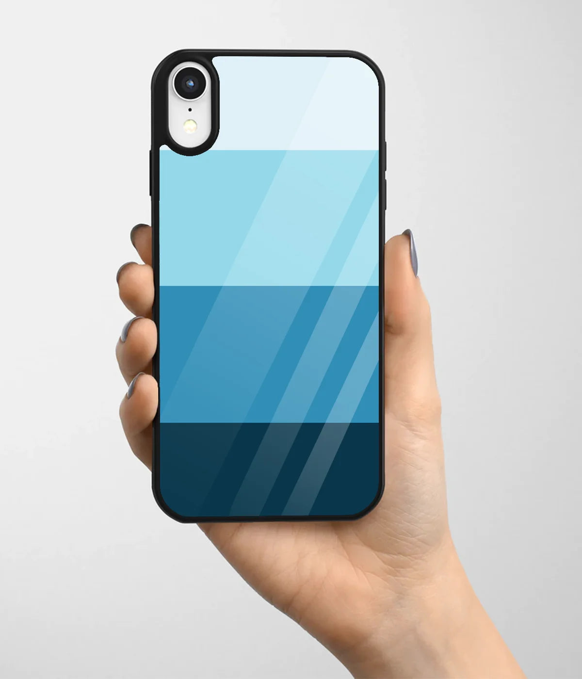 A hand holding a glass phone case with a colorful design.