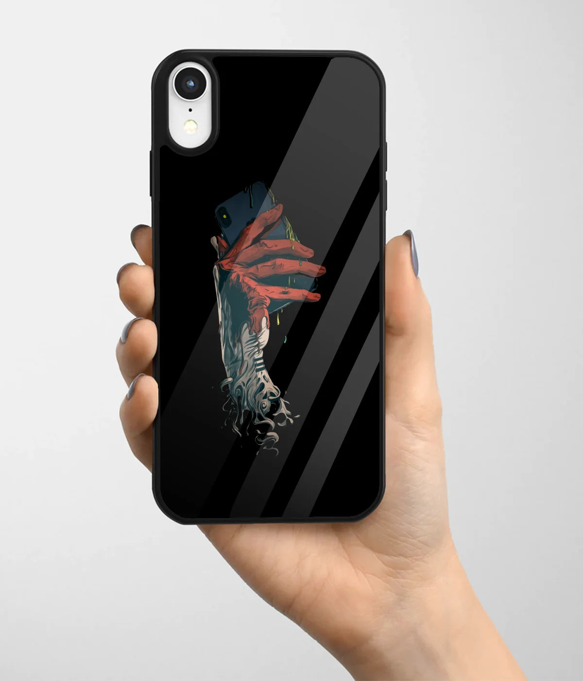 A hand holding a glass phone case with a colorful design.