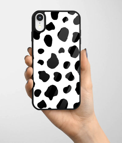 A hand holding a glass phone case with a colorful design.
