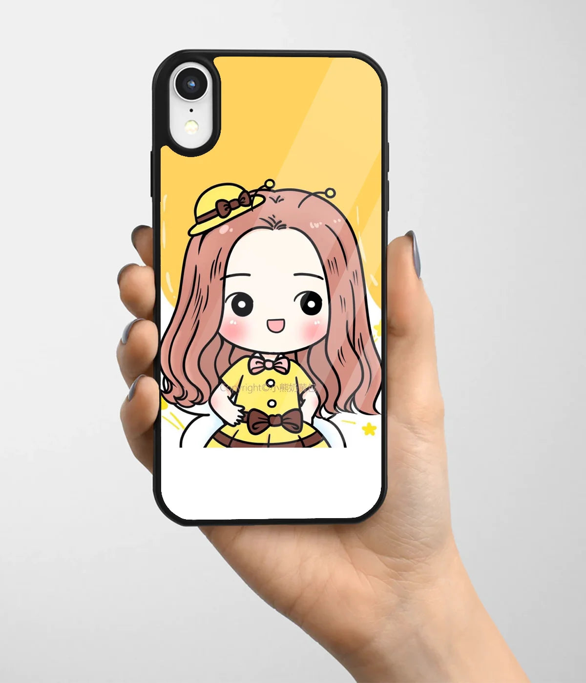 A hand holding a glass phone case with a colorful design.