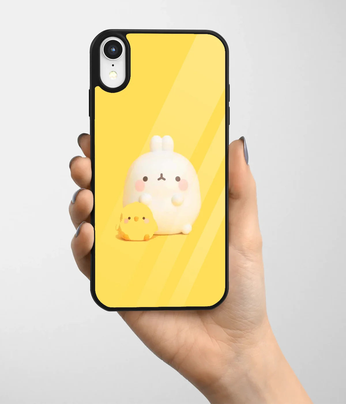 A hand holding a glass phone case with a colorful design.
