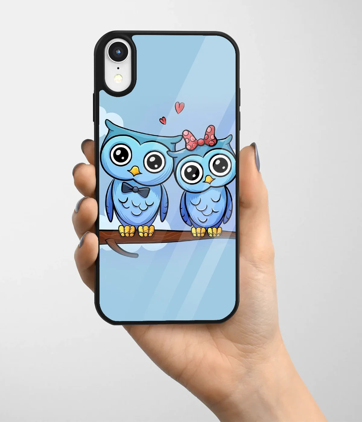 A hand holding a glass phone case with a colorful design.